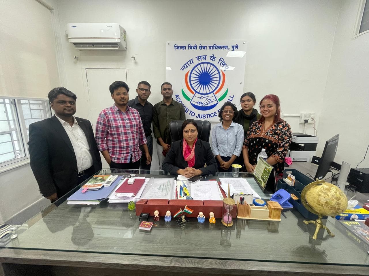 AJP team in office with Access to Justice logo